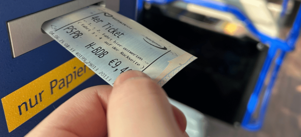 Eine Person entwertet ein 4er Ticket für Erwachsene im Entwerter im Bus.