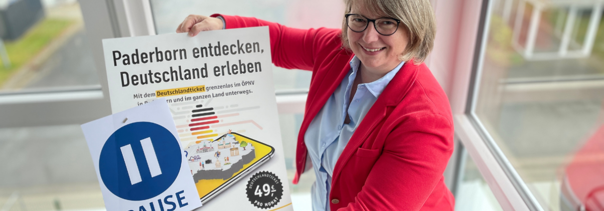 Eine Frau hält ein Plakat für die AboPause beim Deutschaldticket hoch