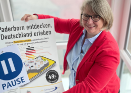 Eine Frau hält ein Plakat für die AboPause beim Deutschaldticket hoch