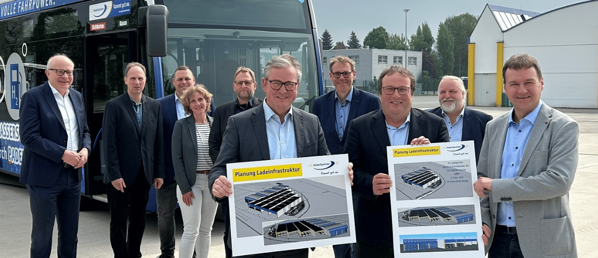 Es stehen 10 Personen vor einem Wasserstoffbus auf dem Betriebshof des PaderSprinter. NRW-Minister Oliver Krischer, Paderborns Bürgermeister Michael Dreier und PaderSprinter-Geschäftsführer Oliver Eikenberg halten Hartschaumplatten in die Kamera.