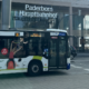 Ein Bus des PaderSprinters fährt vor dem Bahnhofsgebäude des Paderborner Hauptbahnhofs her
