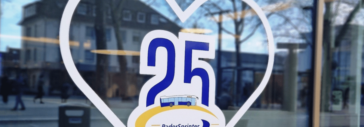 Die Grafik zeigt einen Aufkleber auf einer Glasscheibe. Der Aufkleber ist ein Herz mit dem Jubiläumslogo des PaderSprinter in der Mitte.