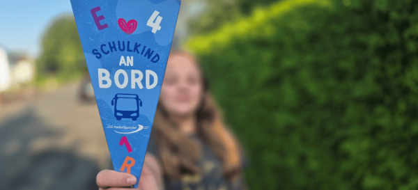 Ein junges Mädchen hält eine kleine Schultüte im PaderSprinter-Design in die Kamera.
