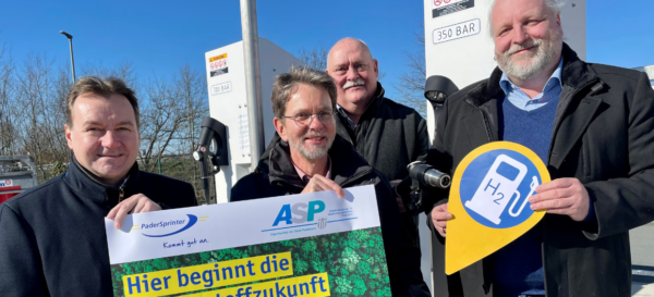 Vier Personen präsentieren die Wasserstofftankstelle des PaderSprinters