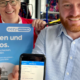 Zwei Mitarbeiter des PaderSprinters präsentieren den eezy-Tarif mit einem Plakat sowie der Fahrplan-App