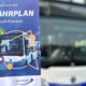 Ein Mitarbeiter zeigt das Fahrplanheft ab 24.03.2024 vor einem PaderSprinter-Bus