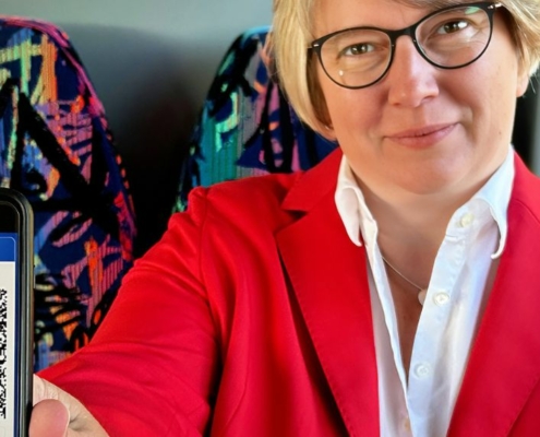 Frau zeigt ein Handy in die Kamera