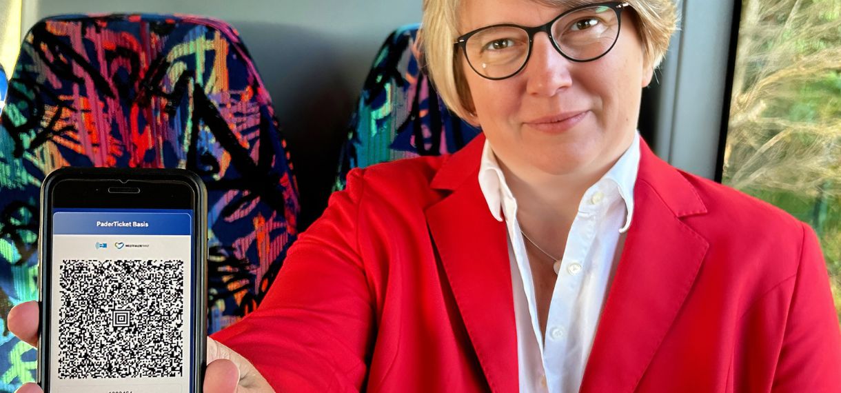 Frau zeigt ein Handy in die Kamera