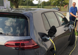 Bernhard Hengsbach und Philipp Bosseler betanken ein Elektroauto an einer der neuen Ladesäulen am Betriebshof