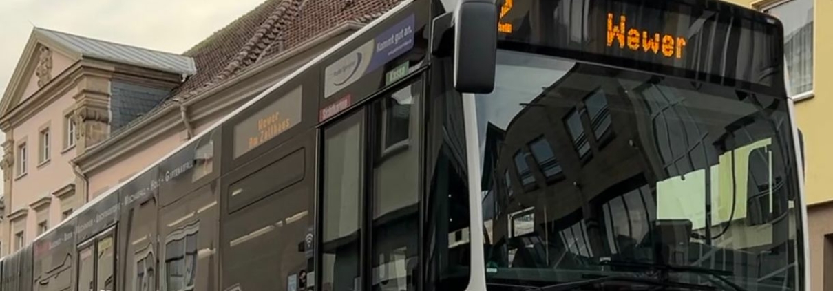 Ein Bus in einer Stadt. Die Bus-Außenanzeige zeigt die Linie 12 in Richtung Wewer an.
